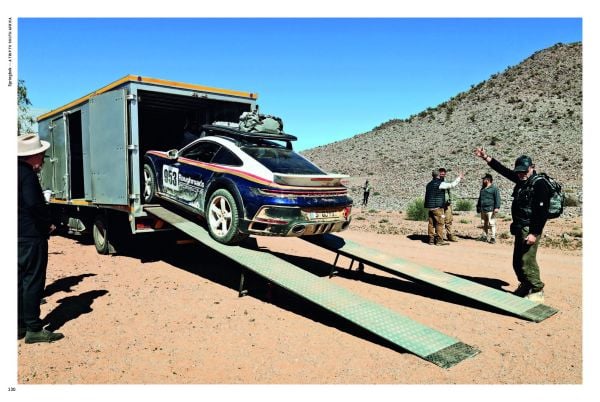 Book cover of Rough Roads to 911 Dakar, featuring a black Porsche 911 racing down a sand dune in the desert. Published by Delius.