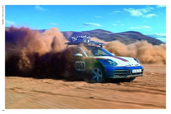 Book cover of Rough Roads to 911 Dakar, featuring a black Porsche 911 racing down a sand dune in the desert. Published by Delius.