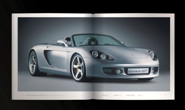 Book cover of Porsche Carrera GT, with a gray sportscar driving on roads around mountainous landscape. Published by Delius Klasing Verlag GmbH.