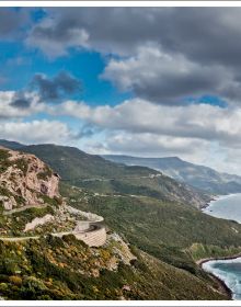 Book cover of Stefan Bogner's CURVES Italy/Sardinia: Volume 23, with a winding road through a mountainous landscape. Published by Delius Klasing Verlag GmbH.