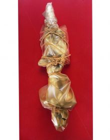 Christo putting arm around Jeanne-Claude, both holding white hard hats, installation space with workers behind, Christo and Jeanne-Claude Projects 1963-2020 in orange font to centre.