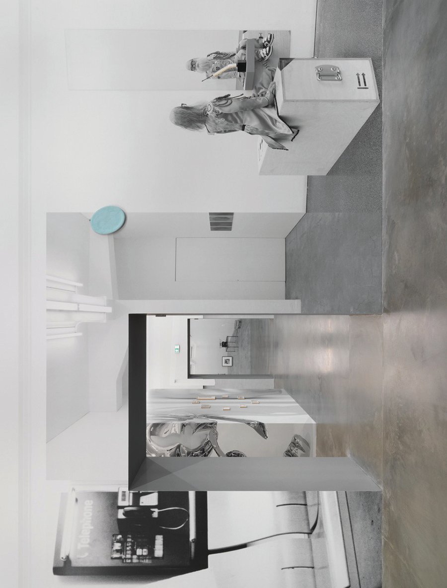 Exhibition interior space with large photographic portrait of seated man holding a sheet of paper.