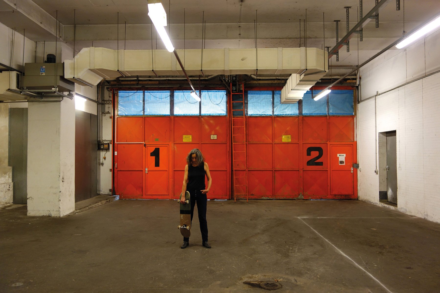 Figure in red dress walking towards high rise, Simone Zaugg in white font, THOUGHTS TO GO in red font