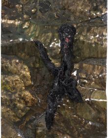 Black, red and green entrails-like sculpture protruding out of floor in exhibition space, REMAINS Zsolt Berszán in grey font above, by Kerber.