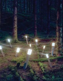 Book cover of Rune Guneriussen Lights go out, with a light installation on wood structure, in a dark forest setting. Published by Kerber.