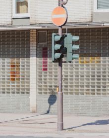 Exterior of building with salmon pink scalloped door overhang, curved steps, on white cover, IRIS FRIEDRICH GRAU MELIERT pepper and salt in grey, black and pink font down left edge.