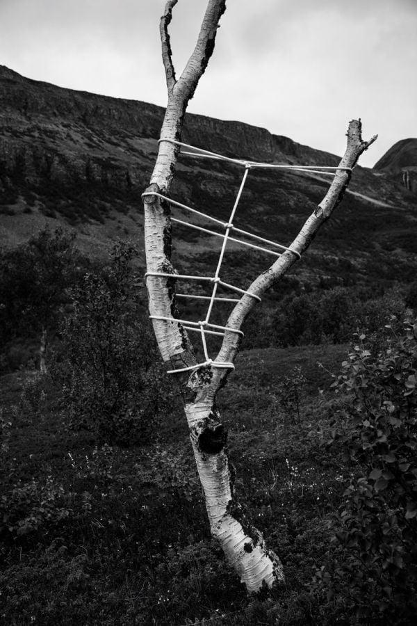 Book cover of Anna Reivilä, Nomad, with a large grey rock bound in rope, on coastal edge. Published by Kerber.