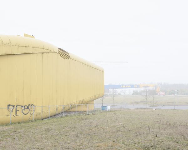 Multi-storey structure obscured by mist, on grey landscape cover of 'Piet Niemann, Expo 2000', by Kerber.