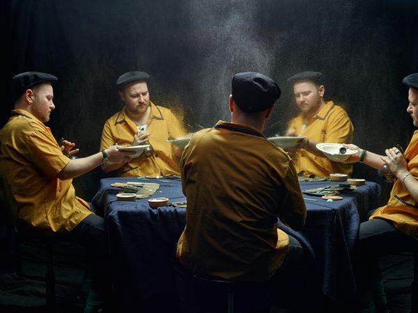 Landscape book cover of René Riis, Conversation with My Other Me, with mirrors creating five images of the same man with large grey beard, wearing a red and white checked jacket, sitting at table. Published by Kerber.