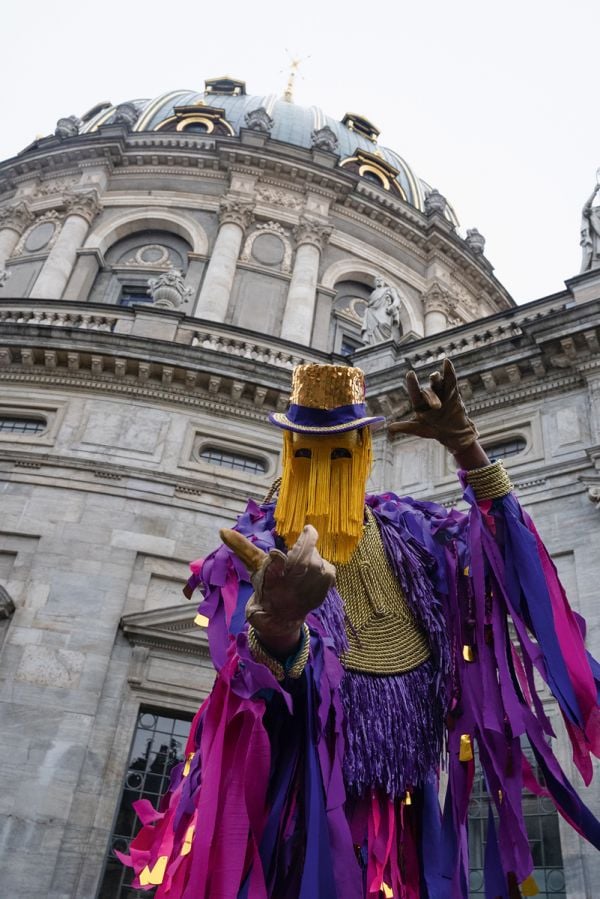 Repeated slide of pair of eyes, on mustard yellow cover of 'MOMENTA Biennale de l’image, Masquerades: Drawn to Metamorphosis', by Kerber.