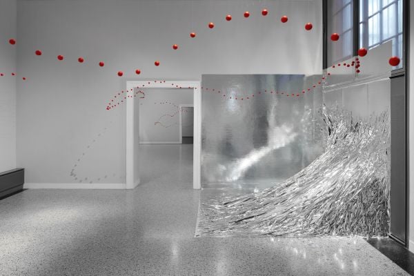 Book cover of Between One Line: Katharina Hinsberg & Monika Gryzmala, with an art installation of white wire and small red balls. Published by Kerber.