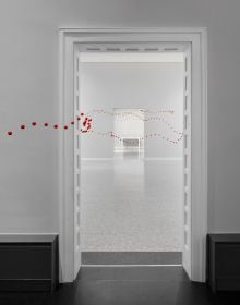 Book cover of Between One Line: Katharina Hinsberg & Monika Gryzmala, with an art installation of white wire and small red balls. Published by Kerber.