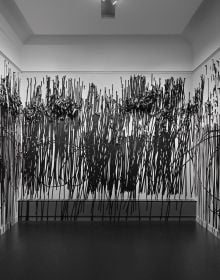 Book cover of Between One Line: Katharina Hinsberg & Monika Gryzmala, with an art installation of white wire and small red balls. Published by Kerber.
