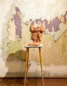 Book cover of Tempel: Susanne Ring, with a clay figurine with arms in the air, standing on wall shelf. Published by Kerber.