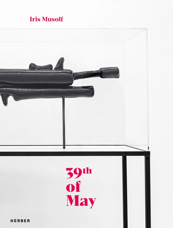 Book cover of Iris Musolf: 39th of May; featuring an art exhibit resembling a gun, inside a clear box. Published by Kerber.
