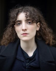Book cover of Being Young: Portraits of Becoming; featuring a portrait of young woman with a septum piercing, wearing bold earrings and a pink scarf. Published by Kerber.