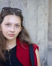 Book cover of Being Young: Portraits of Becoming; featuring a portrait of young woman with a septum piercing, wearing bold earrings and a pink scarf. Published by Kerber.