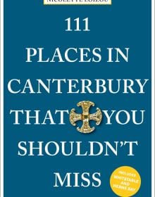 Gold Canterbury cross near center of dark blue cover of '111 Places in Canterbury That You Shouldn't Miss', by Emons Verlag.