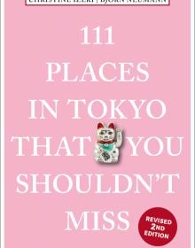 Maneki-neko or beckoning cat near center of baby pink cover of '111 Places in Tokyo That You Shouldn't Miss', by Emons Verlag.