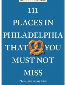 Book cover of 111 Places in Philadelphia That You Must Not Miss, with a pretzel. Published by Emons Verlag.
