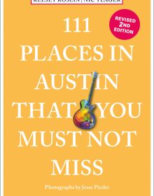 Rainbow coloured electric guitar near centre of peach cover of '111 Places in Austin That You Must Not Miss', by Emons Verlag.