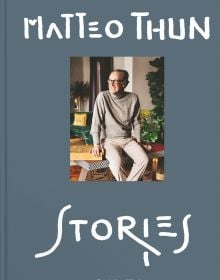 Book cover of Matteo Thun's Stories, with the architect sitting on a table, smiling while looking to his right. Published by Callwey.
