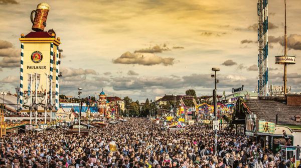 Book cover of Be a Guest at the Oktoberfest: Stories, Recipes and Hidden Treasures, with a pretzel, tuba, big wheel, and tankard of beer. Published by Callwey.