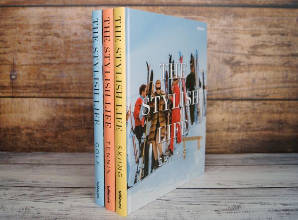 Book cover of The Stylish Life: Skiing, with a group of fashion models in vintage ski wear standing on snow. Published by teNeues Books.