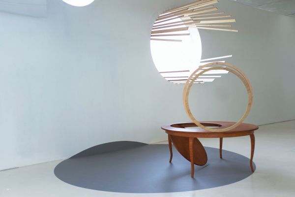 Black circle attached to smaller orange circle by fine thread on grey cover, Barbara Davi Train of Thought in white and black font above