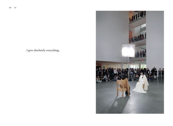 Marina Abramovic in black, seated, with hands in air, on mint green cover of 'Psychoanalyst Meets Marina Abramovic, Artist meets Jeannette Fischer', by Scheidegger & Spiess.