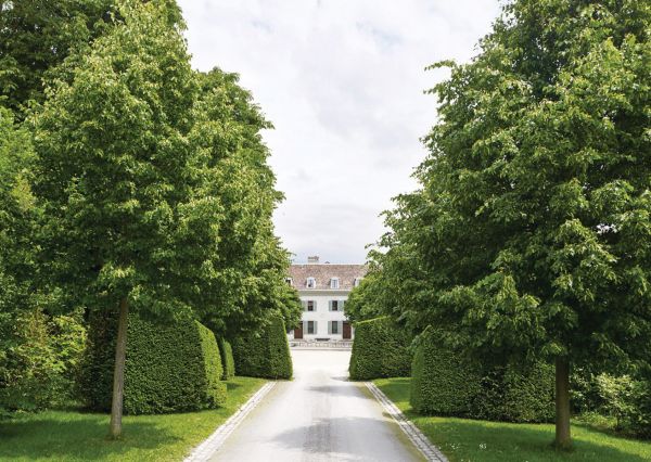 Low topiary hedges, large trees behind, on coral cover, The Gardens of La Gara in green font to lower left