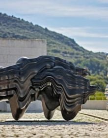 Tall curved wood sculptures in exhibition space, Anthony Cragg Endless Form in white font to upper left