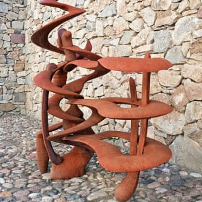 Tall curved wood sculptures in exhibition space, Anthony Cragg Endless Form in white font to upper left