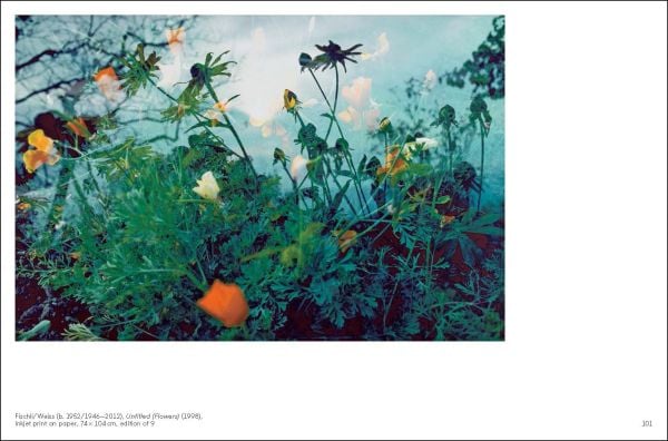 Framed image of Mickey Mouse leaning against white interior wall with mirror and chandelier above, The Julius Baer Art Collection in black font above.