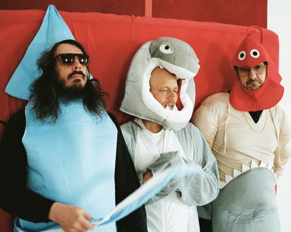 White book cover of Bavid Dowie, with a photo of three men walking away from camera, down a residential street. Published by Verlag Kettler.