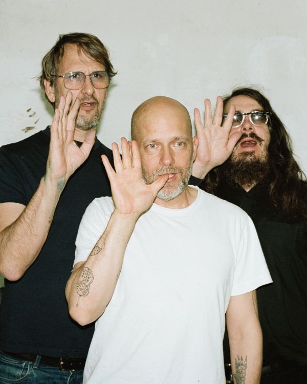 White book cover of Bavid Dowie, with a photo of three men walking away from camera, down a residential street. Published by Verlag Kettler.
