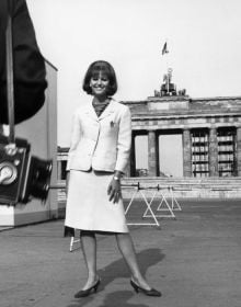 Book cover of Between the Films, A Photo History of the Berlinale, with James Stewart in suit and trilby, standing near water fountains with high-rise behind. Published by Verlag Kettler.