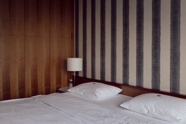 Cream book cover of My Friends Got Famous, with red and white striped flip flop floating on top of in blue swimming pool water. Published by Verlag Kettler.