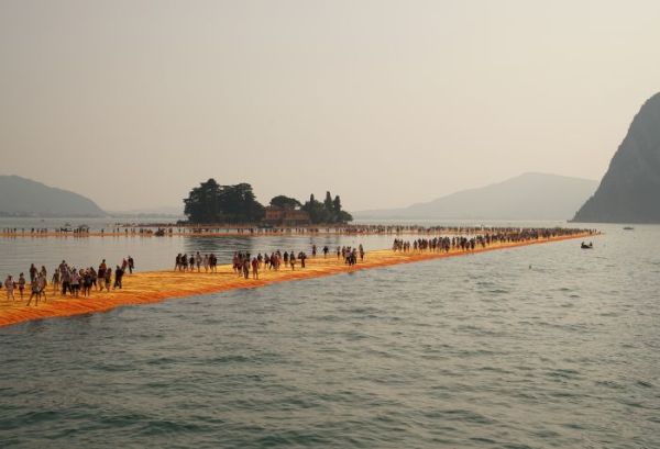 Book cover of Christo and Jeanne-Claude: In/Out Studio, with young man perched on low stool in studio facing away from viewer. Published by Verlag Kettler.