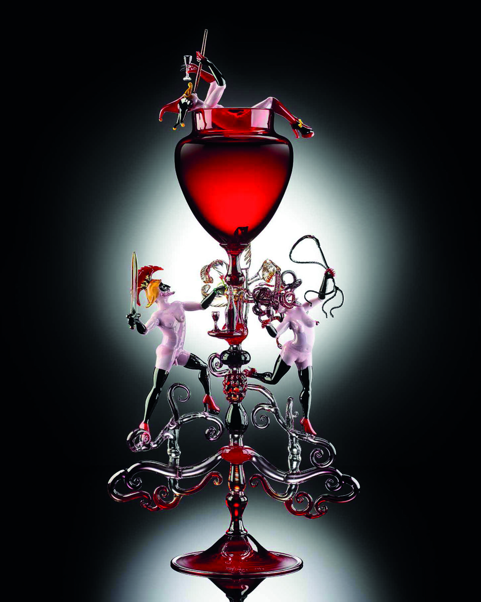 Blood red glass bowl, glass figure in red suit and mask with black horns, exposed breasts and platform boots, Lucio Bubacco erotics in white font