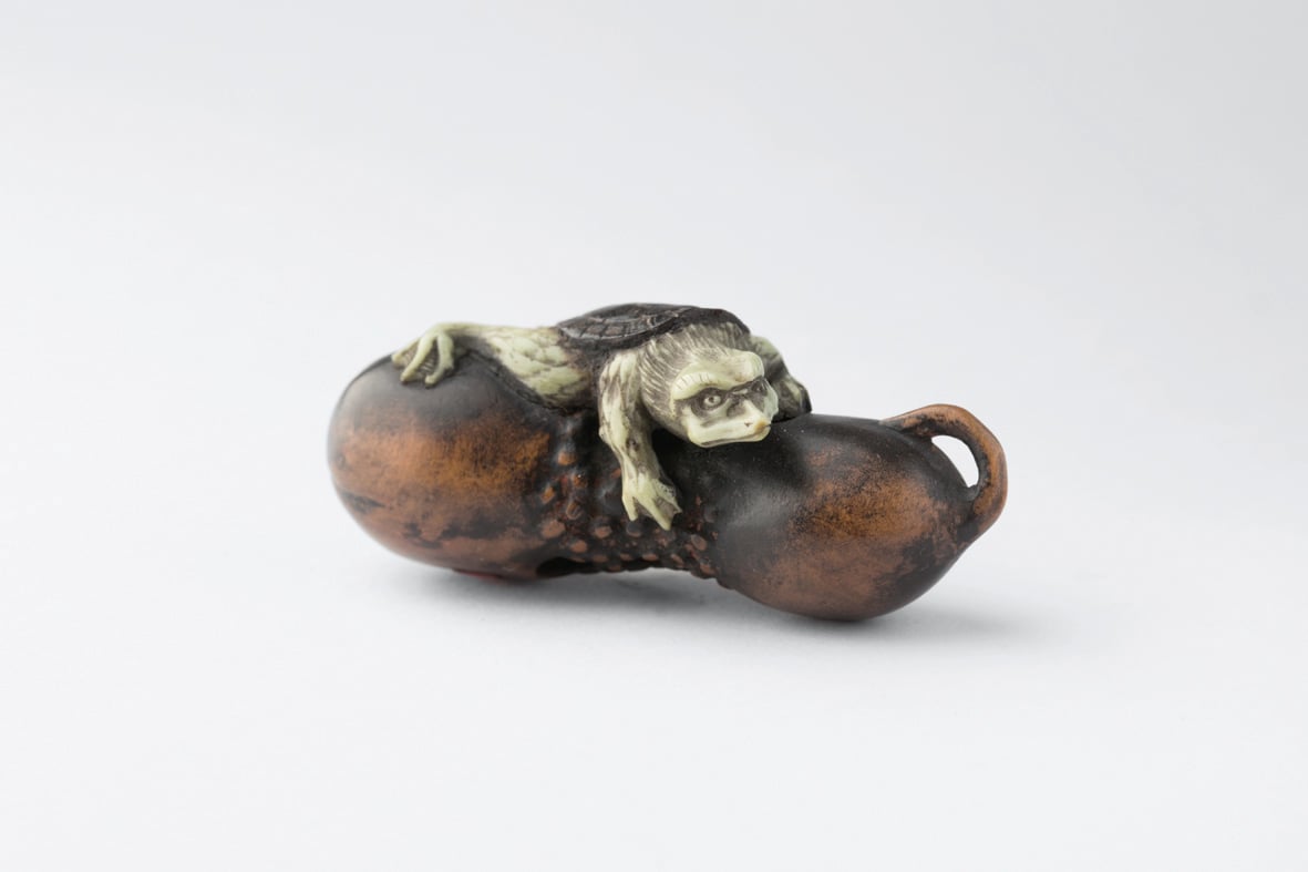 Netsuke of bear in robe, grey cover, Netsuke in Comparison in red font above, red left border