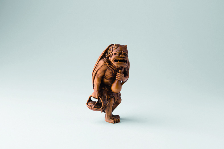 Netsuke of bear in robe, grey cover, Netsuke in Comparison in red font above, red left border