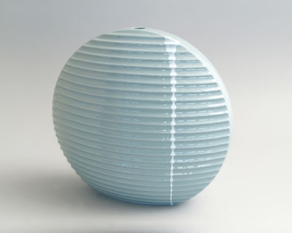 Delicate cream filigree porcelain bowl, on white cover, Barbel Thoelke Porzellan in white and black font below