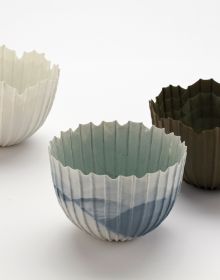 Delicate cream filigree porcelain bowl, on white cover, Barbel Thoelke Porzellan in white and black font below