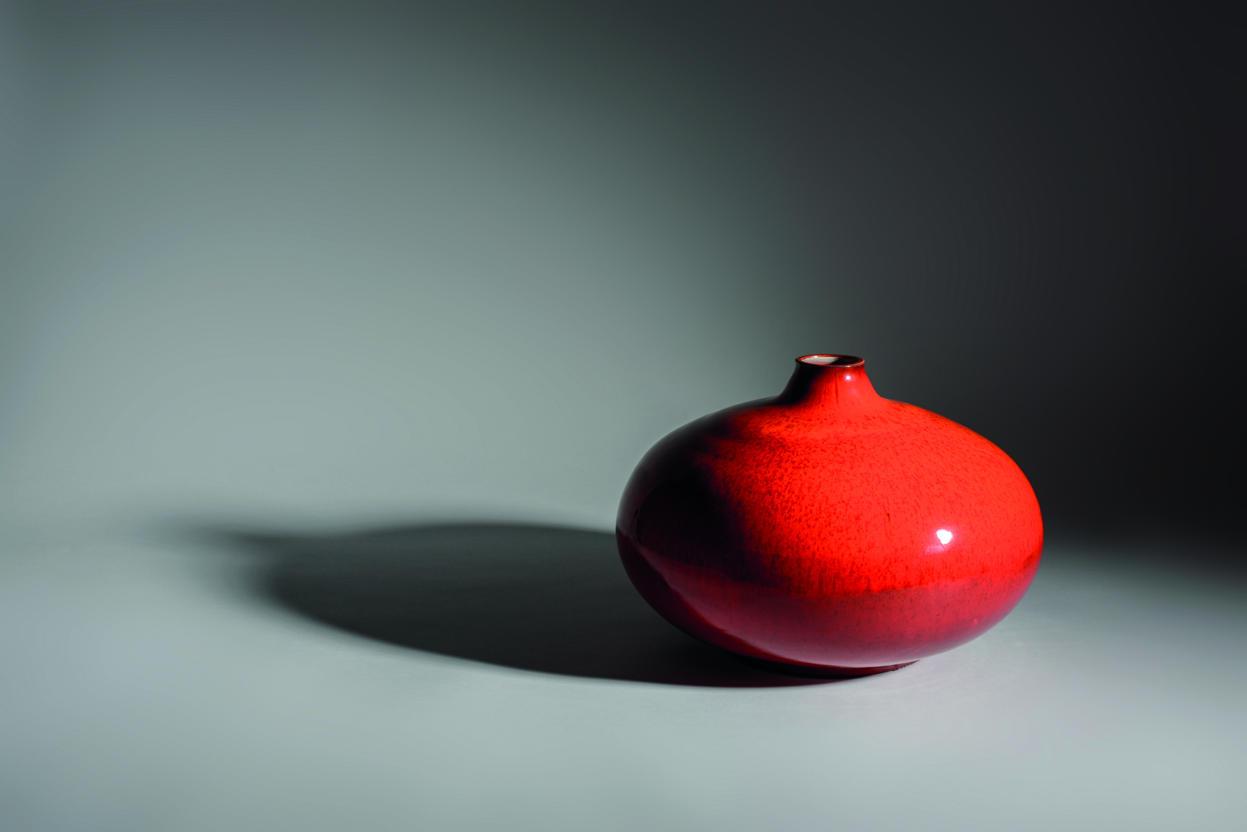 Aerial view of fiery red glazed ceramic pot, amphora Rogier Vandeweghe Ceramics 1957-1975 in white font near centre