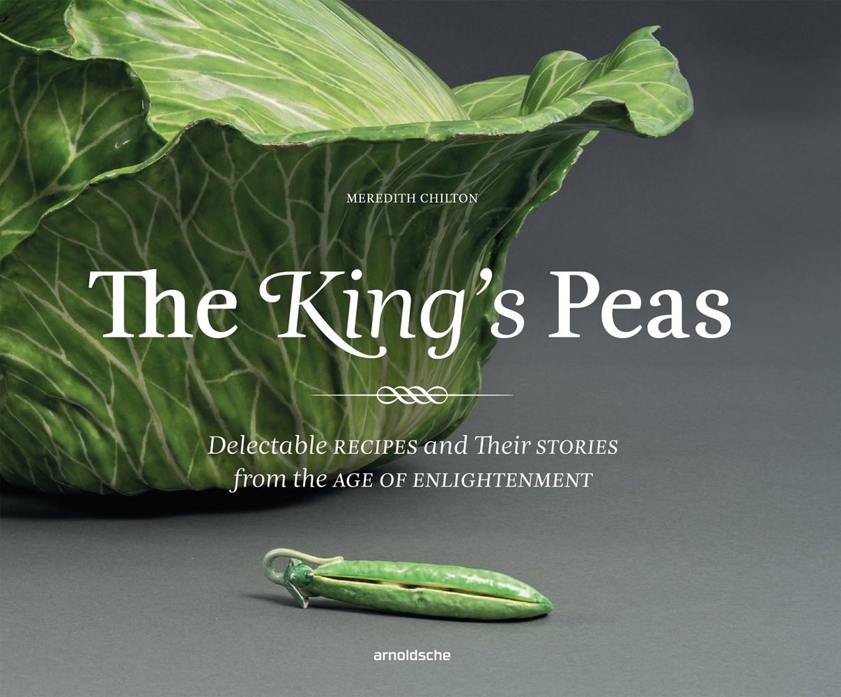 Delicate ceramic green cabbage with pea pod, grey cover, The King’s Peas in white font to centre.
