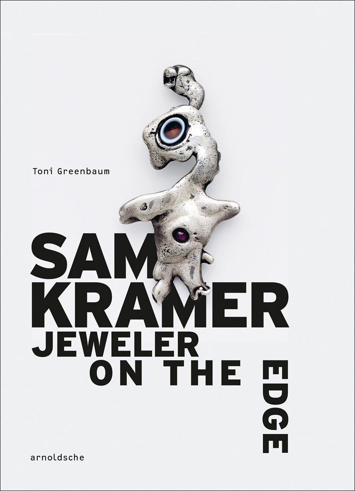 Organic shaped silver metal jeweller with coloured stones, off-white background, SAM KRAMER JEWELER ON THE EDGE in black font above.