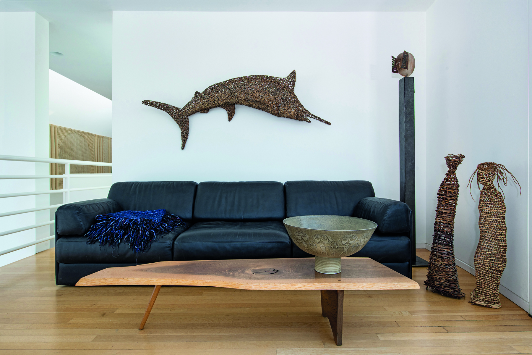 Sculpture of bird made from wood and fibres, on white windowsill looking out, The Grotta Home by Richard Meier in white font to upper left.