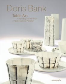 Collection of cream and black cups, saucers and vases, on white and grey cover, of 'Doris Bank, Table Art in Stoneware and Porcelain', by Arnoldsche Art Publishers.