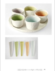 Collection of cream and black cups, saucers and vases, on white and grey cover, of 'Doris Bank, Table Art in Stoneware and Porcelain', by Arnoldsche Art Publishers.